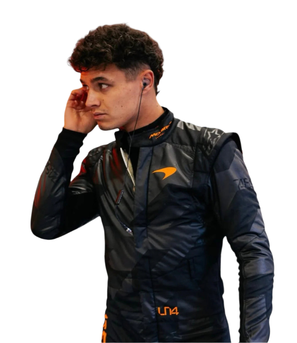 Male model wearing 2025 Lando Norris McLaren race suit in black with orange logo and earbuds